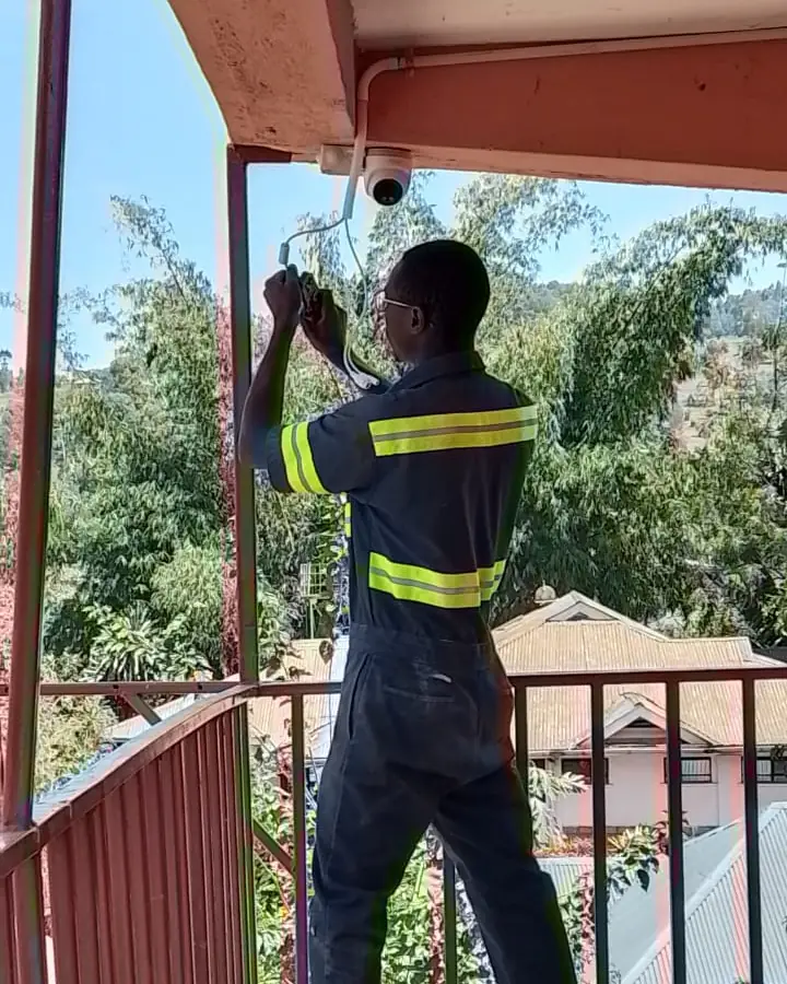 CLAUDNET technician mounting a CCTV dome camera on a balcony